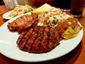 Grilled pork steaks, baked potatoes and bread. Royalty Free Stock Photo