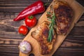 Grilled pork steaks and vegetables on a rustic wooden table. Grilled meat on the bone with spices Royalty Free Stock Photo