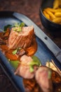 Grilled pork tenderloin with mushroom sauce served on plate with glass of wine and dumplings, modern seasonal gastronomy Royalty Free Stock Photo