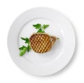 Grilled pork on a white plate with celery leaves