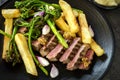 Grilled porterhouse steak with broccolini shallots french fries and mustard