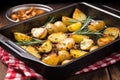 grilled potatoes in roasting pan with rosemary and whole garlic cloves