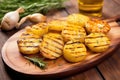 grilled potatoes seasoned with rosemary on a bamboo platter
