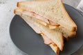 Grilled and pressed toast with smoked ham, cheese, on white marble background. Homemade food. Tasty breakfast. Selective