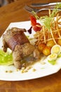 Grilled quail in bacon with fried potatoes, quail eggs and pine nuts