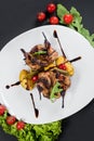 Grilled quail meat with vegetables on black background Royalty Free Stock Photo