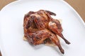 Grilled quail served on a white plate