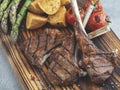 Grilled rack lamb chops on a wooden board with asparagus, red sauce, potatoes Royalty Free Stock Photo