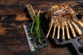 Grilled rack ribs of lamb meat chops. Dark wooden background. Top view. Copy space Royalty Free Stock Photo