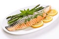 grilled rainbow trout served with asparagus on a white dish