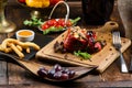 Grilled red bell pepper stuffed with meat and rice, served fresh lettuce on a light wooden board Royalty Free Stock Photo