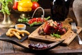 Grilled red bell pepper stuffed with meat and rice, served fresh lettuce on a light wooden board Royalty Free Stock Photo