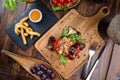 Grilled red bell pepper stuffed with meat and rice, served fresh lettuce on a light wooden board Royalty Free Stock Photo