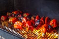 Grilled red bell peppers, fire burning on grill barbecue