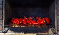 Grilled red bell peppers, fire burning on grill barbecue