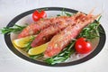 Grilled red mullet in a plate with herbs, tomato and lemon. Healthy food. Mediterannean lifestyle