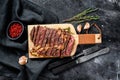 Grilled rib eye, ribeye steak on a chopping Board, medium rare. marbled meat. black background. top view