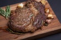 Grilled rib-eye steak of marble beef closeup with spices on wooden Board