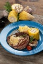 Grilled rib eye steak with vegetables and potato puree in butter sauce Royalty Free Stock Photo