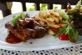 Grilled rib steak serving with french fried and lettuce salad