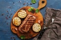 Grilled ribeye beef steak, herbs and spices on blue rustic background. Top view,flat lay Royalty Free Stock Photo