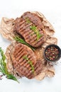 Grilled ribeye beef steak, herbs and spices on a white wooden background. Top view. Royalty Free Stock Photo