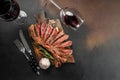 Grilled ribeye beef steak with red wine, herbs and spices. Marbled beef steak medium rare on a black background with copy space Royalty Free Stock Photo