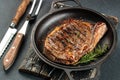 Grilled ribeye beef steak with red wine, herbs and spices. Marbled beef steak medium rare on a black background with Royalty Free Stock Photo