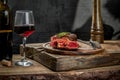 Grilled ribeye beef steak with red wine, herbs and spices on wooden table Royalty Free Stock Photo