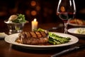 Grilled Ribeye Steak with butter and herbs, served with baked asparagus and a glass of red wine on a steak house or meat Royalty Free Stock Photo