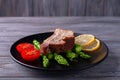 Grilled ribs with green asparagus, tomatoes and lemon on a plate Royalty Free Stock Photo