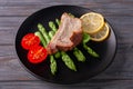 Grilled ribs with green asparagus, tomatoes and lemon on a plate Royalty Free Stock Photo