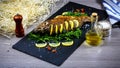 Grilled river fish on a plate with lemon and baked vegetables and parsley. Food recipe photo, copy text Royalty Free Stock Photo