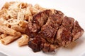 Grilled roasted Entrecote steak meat on a white plate with pasta and cheese isolated on white