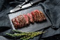 Grilled roasting rare sliced skirt, machete steak. Marble meat beef. Black background. Top view