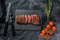 Grilled roasting rare sliced top blade, Denver steak. Marble meat beef. Black background. Top view Royalty Free Stock Photo