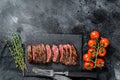 Grilled roasting rare sliced top blade, Denver steak. Marble meat beef. Black background. Top view. Copy space Royalty Free Stock Photo