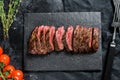 Grilled roasting rare sliced vegas strip steak. Marble meat beef. Black background. Top view