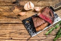 Grilled rump cap or brazilian picanha beef meat steak on a cleaver. wooden background. Top view. Copy space