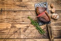 Grilled rump cap or brazilian picanha beef meat steak on a cleaver. wooden background. Top view. Copy space