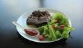 Grilled rump steak served with tomatoes, salad, hot sauce and thin pita bread Royalty Free Stock Photo