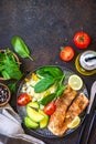 Grilled salmon fillet close-up with couscous, salad fresh vegetables and avocado on dark background. Top view flat lay. Royalty Free Stock Photo