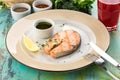 Grilled salmon fillet with soy sauce and slice of lemon on blue wooden table Royalty Free Stock Photo