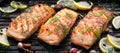 Grilled salmon fillets sprinkled with fresh herbs on a grill plate