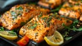 Grilled salmon fillets sprinkled with fresh herbs and lemon juice on a grill plate close up Royalty Free Stock Photo