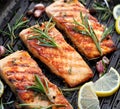 Grilled salmon fillets sprinkled with fresh herbs and lemon juice on a grill plate Royalty Free Stock Photo