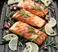 Grilled salmon fillets sprinkled with fresh herbs and lemon juice on a grill plate Royalty Free Stock Photo