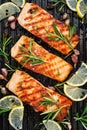 Grilled salmon fillets sprinkled with fresh herbs and lemon juice on a grill plate Royalty Free Stock Photo