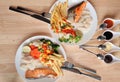 Grilled salmon fish and baked cod fish decorated with various vegetables corn carrot peas lemon french fries and sauces Royalty Free Stock Photo