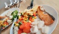 Grilled salmon fish and baked cod fish decorated with various vegetables corn carrot peas lemon french fries and sauces Royalty Free Stock Photo